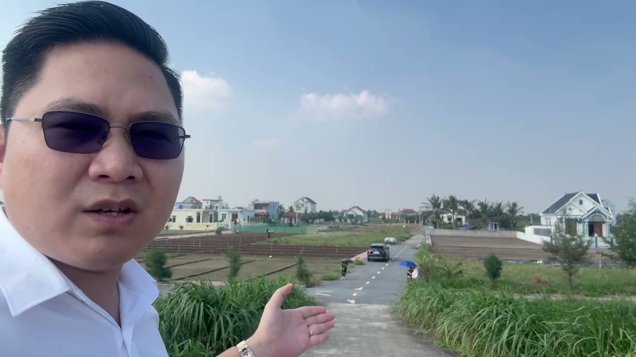 Làng ven biển Giao Ninh phía sau đê, nhà mái ngói xanh đỏ, đường bê tông nhỏ và ruộng rau